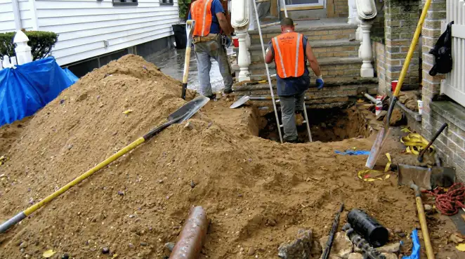 Contractors performing foundation protection and exterior drainage excavation near residential home steps in Shreveport, LA